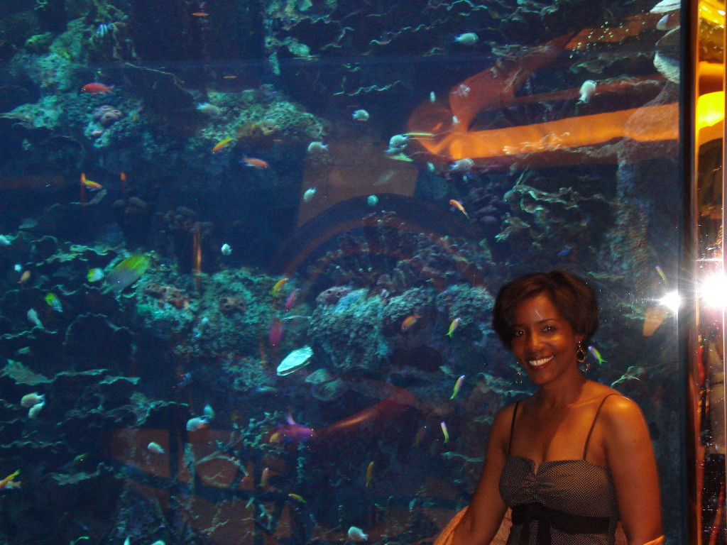 Posing by an elaborate fish tank in a hotel lobby