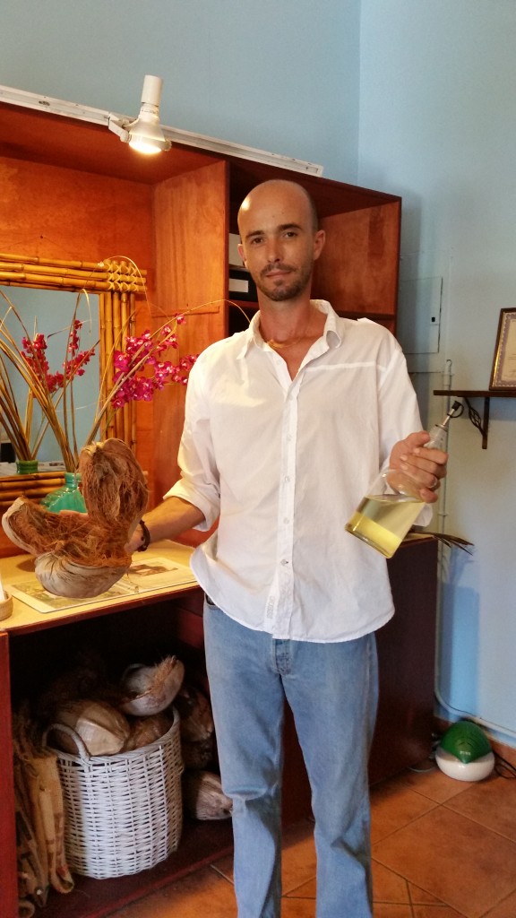 Kristof, the store owner showing the coconut husk and the raw oil.