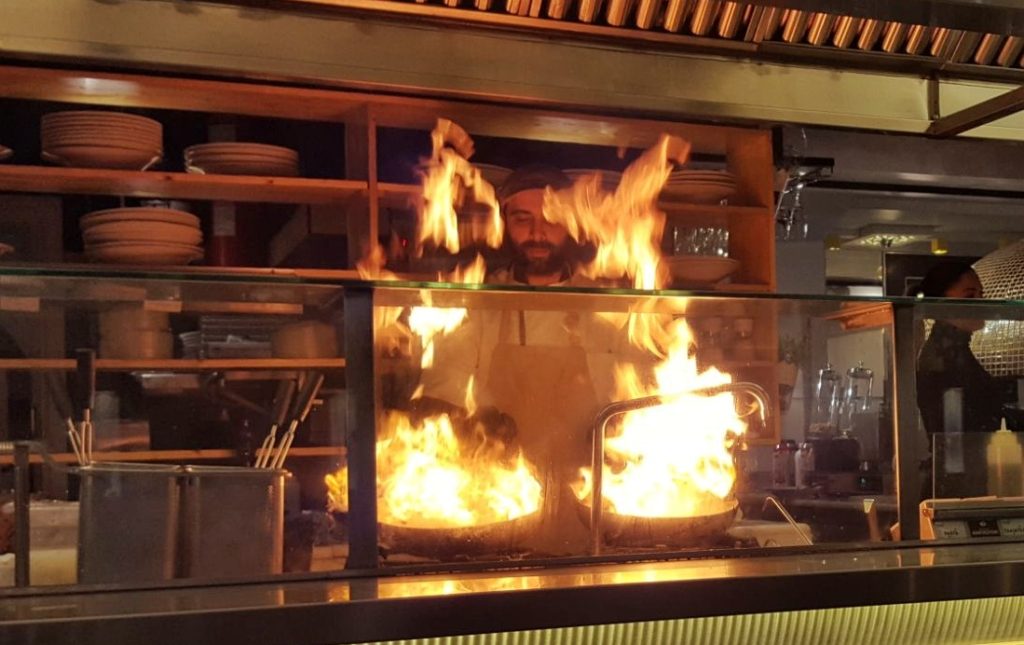 Chef over fire in open kitchen_Athens_Greece