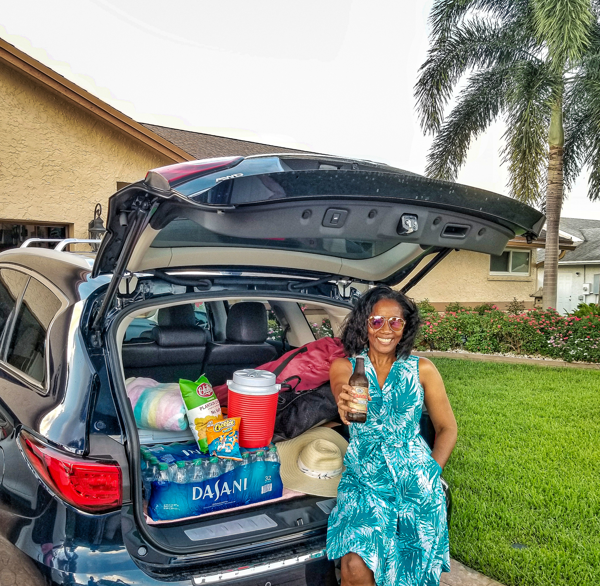 Black woman leaning against trunk of SUV packed or a long road trip